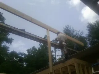 Carpenter setting a ridge beam over a new addition frame — Ice Dam Removal by Roofing Brothers in Arnoldsburg