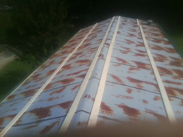 Rusted metal roof panels with new wood purlins before replacement — Storm Damage Roof Repair in Arnoldsburg by Roofing Brothers
