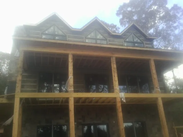 Dormers and porch framing on a large log home under construction — Roof Coating work by our crew in Arnoldsburg