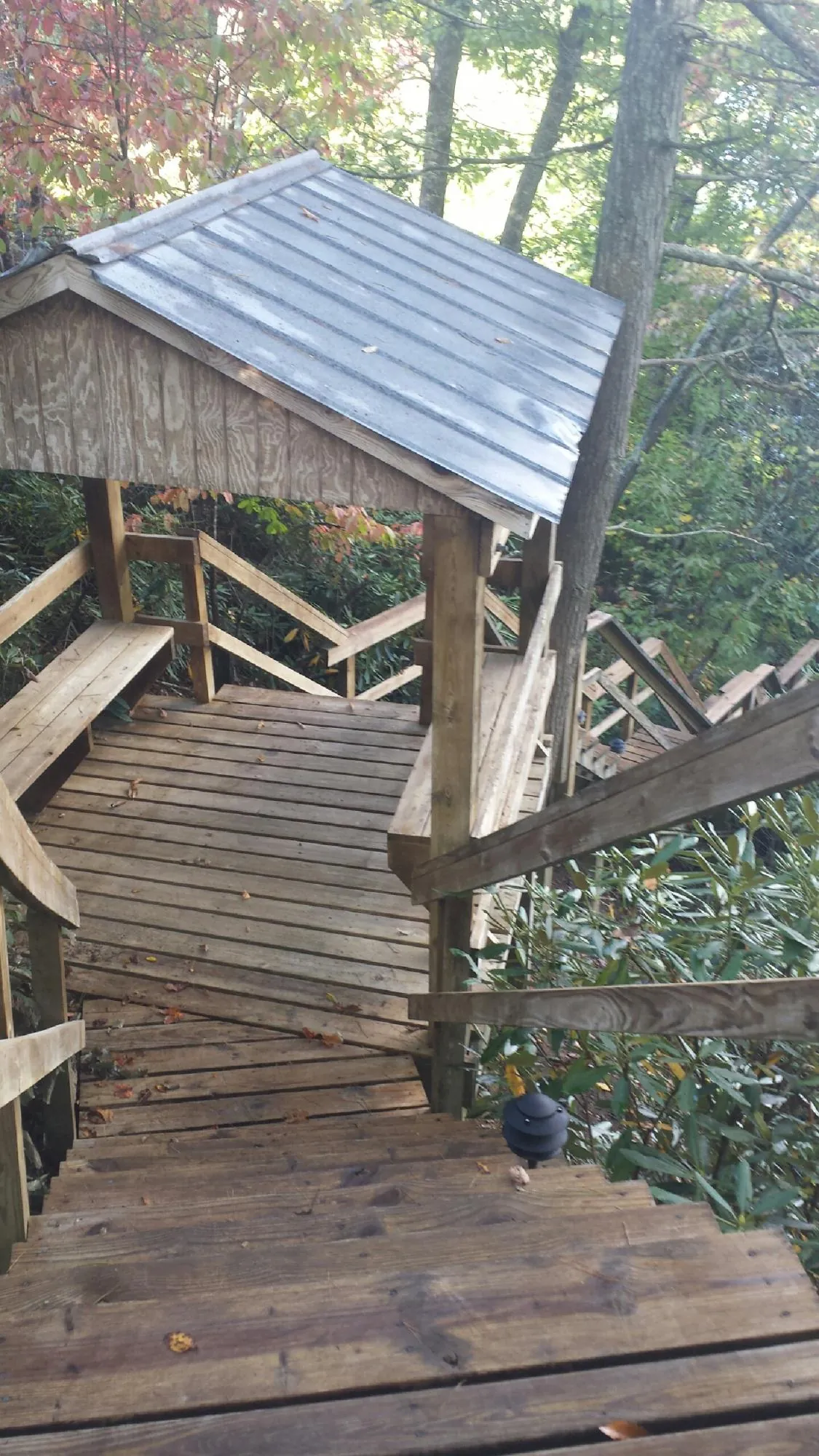 Metal roofed shelter over wooden steps on a wooded walkway — Skylight Repair & Installation work by our crew in Arnoldsburg