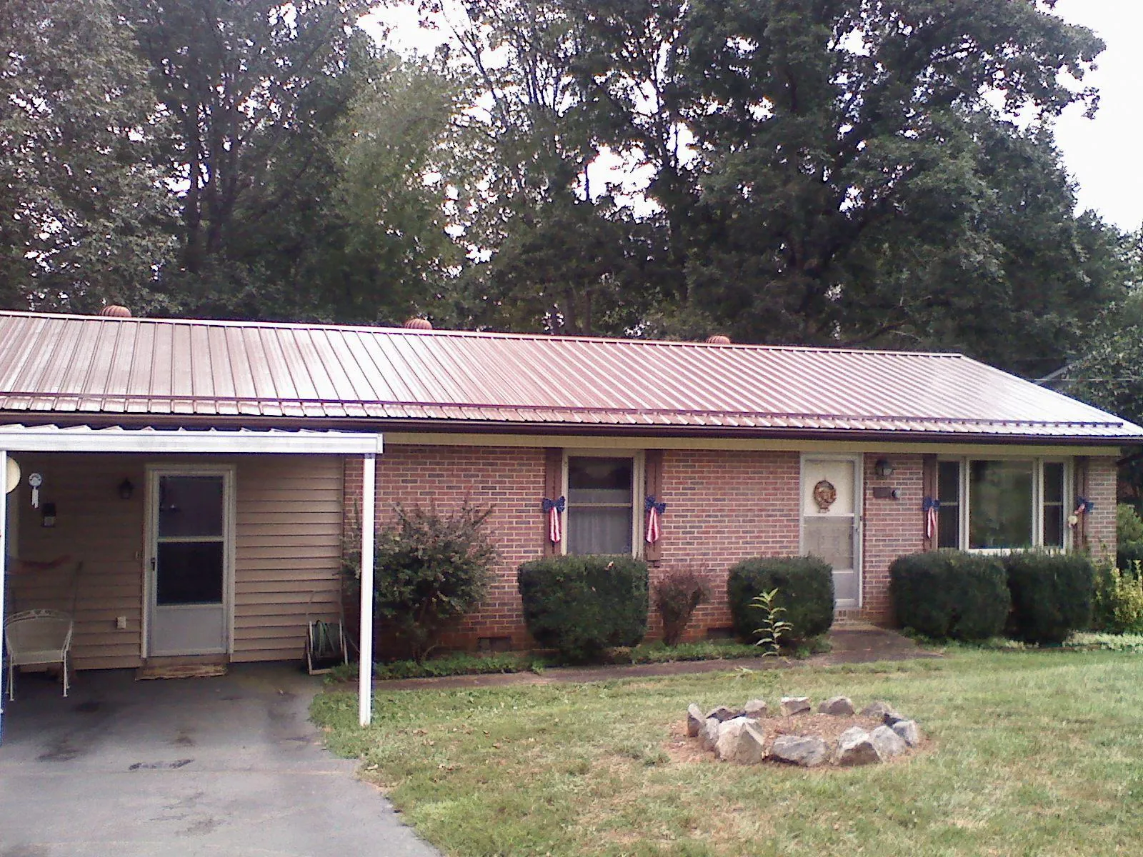 Bronze metal roof and carport on a brick ranch home — Roof Repair work by our crew in Arnoldsburg